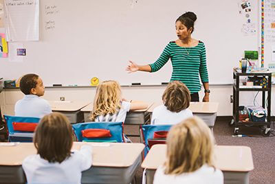 Teacher in front of fourth grade classroom