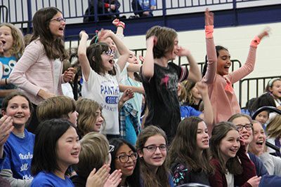 students cheering at give to the max day assembly