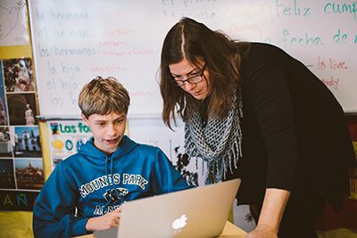 Teacher with student at laptop