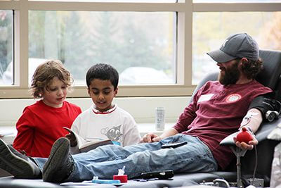 first graders reading to a blood drive donor