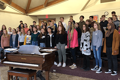 Upper school choir practicing the alma mater