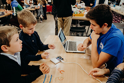 upper school student doing stem activities with lower schoolers