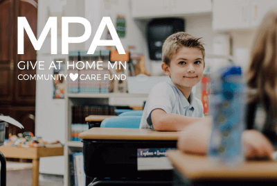 lower school student smiling at his desk