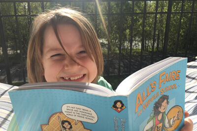 lower school student reading outside