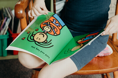 student reading a book in her lap