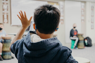 middle school student raising his hand