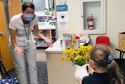 Kindergarten student delivering flowers to a teacher