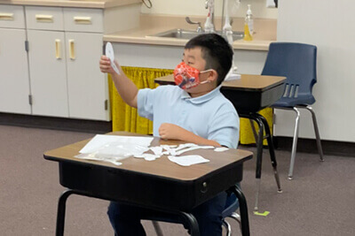 third grader working hands on in the classroom