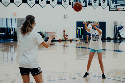 middle school girls passing a basketball