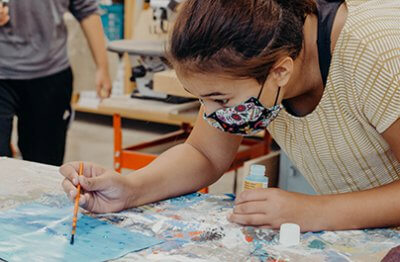 middle school student painting in the makerspace