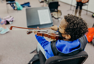 middle school student playing an orchestra instrument