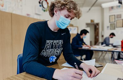 upper school student wearing spirit store shirt in class