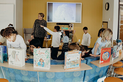 students looking at books in the library