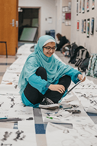 Upper school student working on paintings