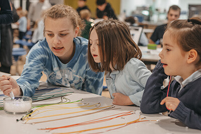 Upper school student working with lower school student on STEM project