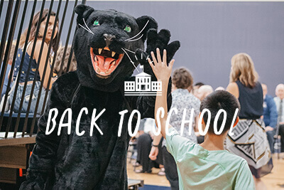 Panther high fives student on back to school night