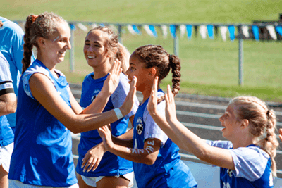 soccer players exchanging high fives at homecoming 