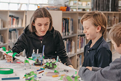 Upper school student working with Lower School student during hour of code week