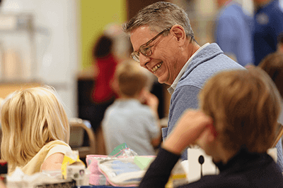 Head of School, Dr. Bill Hudson smiles at a student