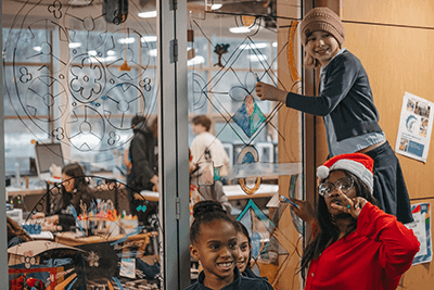 Students smiling while coloring Makerspace glass