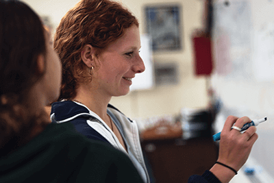 Upper school students working together writing on the board