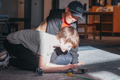 Two middle school students coding with sphero