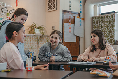 Middle school students talking together in classroom