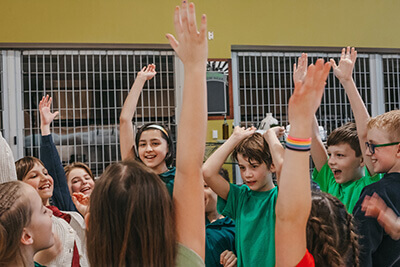 Lower School students celebrate with their hands up in the air. 