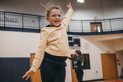 Lower school student jumping in gymnastics. 