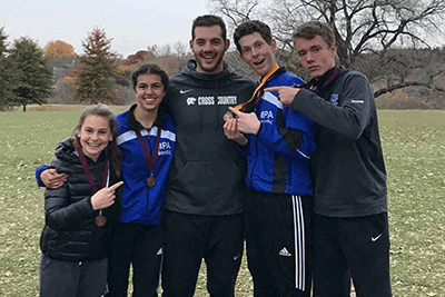 Coach Nate Bander '09 posing with students. 