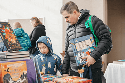 A parent and child shopping at the MPA Book Festival. 