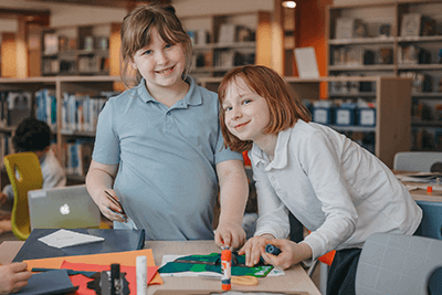 Lower School students putting together a project in the library.