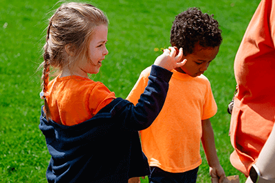 A Lower School student inspects a plant closely. 