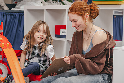 Upper School student reading to a kindergartner