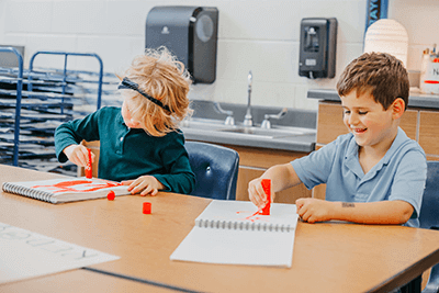 Two Lower School students working on art. 