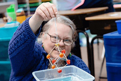 Tami Fisher, second-grade teacher at Mounds Park Academy, works on an in-class demonstration. 