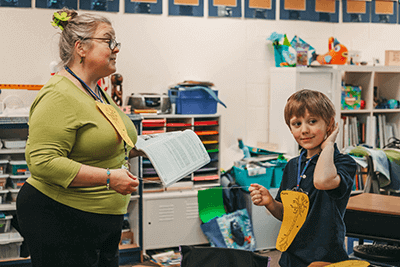 Tami Fisher, second-grade teacher at Mounds Park Academy, works with a student for a class demonstration. 