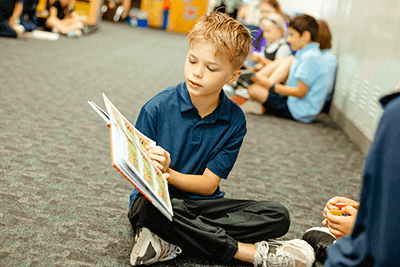 A Lower School student reading his book.