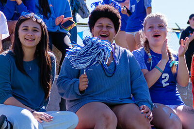 Students cheering on peers at Homecoming