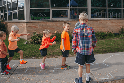PreK students playing outside with fifth grade buddies