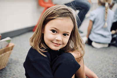 PreK student smiling in her classroom