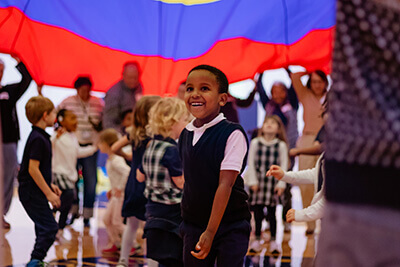Lower School boy in parachute in PE