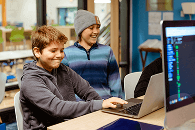 Two students learning while on a computer.