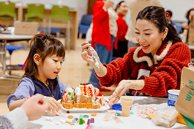 A Lower School student building a gingerbread house.