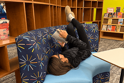 A Middle School student reading her book. 