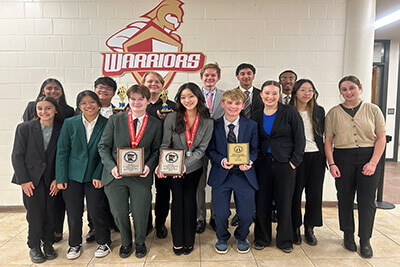 Two MPA students posing with their trophies from the state debate meet. 