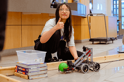 An Upper School student working with a robot