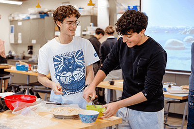 Two Upper School students working together to bake a pie