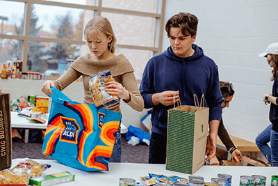 Two students packing up donation bags