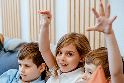 A student smiling and raising her hand
